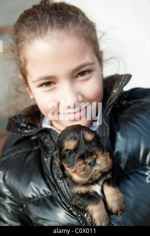 Young girl holding English cocker spaniel in her wind jacket Stock Photo