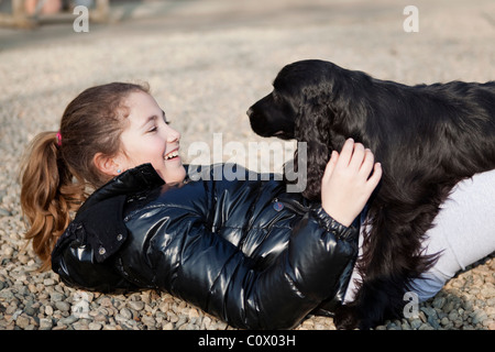 Young girl playing with black cocker spaniel Stock Photo