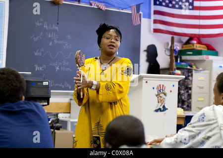 African-American woman in traditional African garb speaks to students during Diversity Day at Park Crest Middle School in Texas Stock Photo