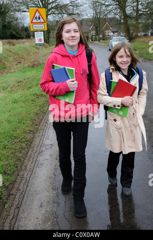 Schoolchildren walking from school along a country lane England UK Stock Photo