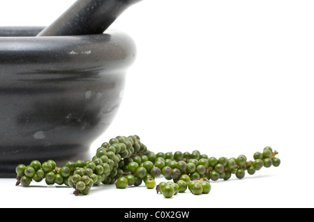 Unprocessed green peppercorns with mortar over white background Stock Photo