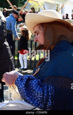 Elderly lady in traditional costume spinning wool at a Handicraft Fair, Ibiza, Spain Stock Photo