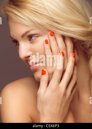 License available at MaximImages.com - Beauty portrait of a young woman with bright orange nail polish Stock Photo
