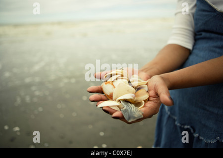 Punjabi woman holds collection of shells from the beach, Manawatu, New Zealand. Stock Photo