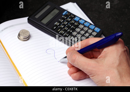 Coins, calculator, hand writing on white striped paper with blue pen Stock Photo