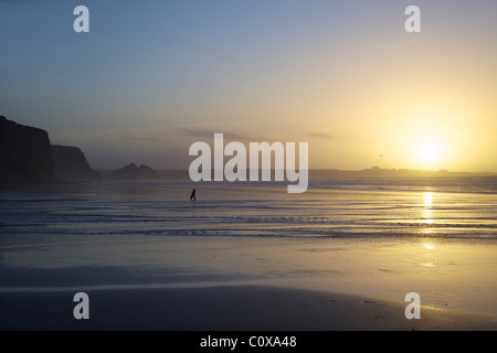 Toddler running along beach at sunset, Watergate Bay, Cornwall, South West England, UK, United Kingdom, GB, Great Britain Stock Photo