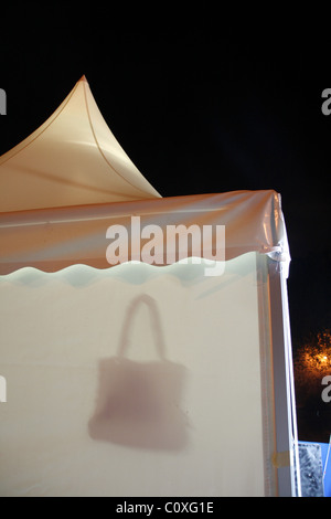 handbag for sale on market stall tent at night at event Stock Photo