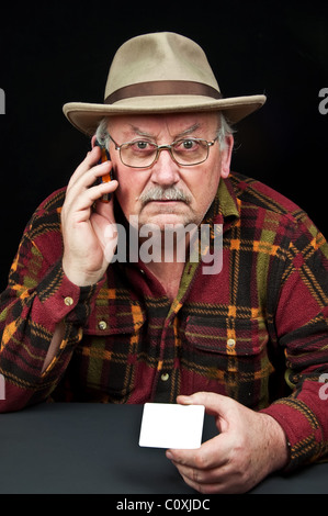 photo senior male with hat on phone with white card Stock Photo