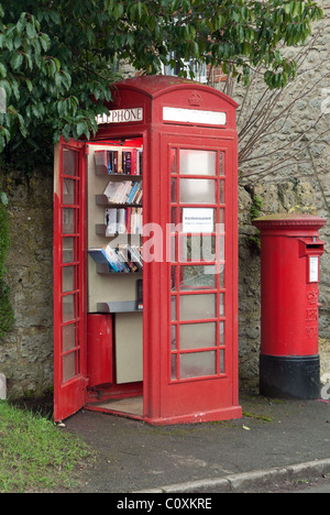 A UK village's redundant BT red telephone box now adopted by the parish council, and converted into a 'Bookswap' mini library. Stock Photo