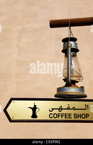 A sign points towards a coffee shop at a tourist attraction in Oman. Stock Photo