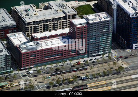 aerial view above San Francisco Muni Light Rail tracks trains at residential condominium buildings Stock Photo
