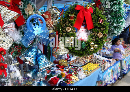 Decorations for sale in Christmas market , girl in background , La Paz , Bolivia Stock Photo