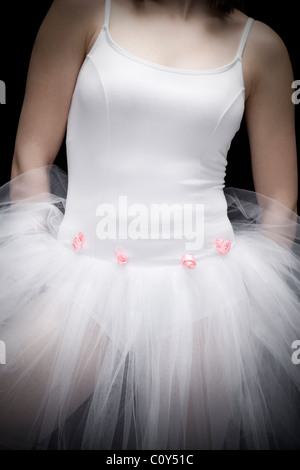 Portrait of teenage ballerina wearing a white tutu with small pink flowers. Stock Photo