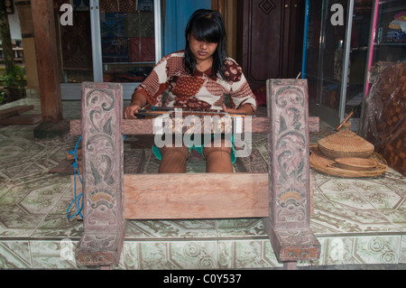 Woman doing traditional ikat weaving in the aboriginal Aga village of Tenganan in eastern Bali Stock Photo