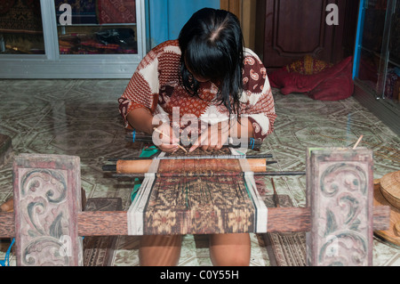 Woman doing traditional ikat weaving in the aboriginal Aga village of Tenganan in eastern Bali Stock Photo