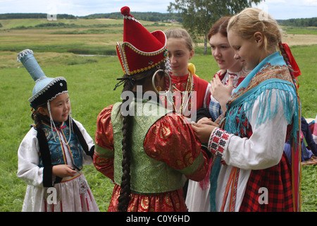 Girls in national buryat et russian costumes at folklore festival in Pushkinskiye Gory. Pskov Region, Russia Stock Photo