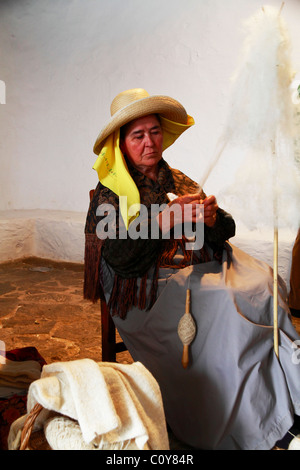 Elderly lady in traditional costume spinning wool at a Handicraft Fair, Ibiza, Spain Stock Photo