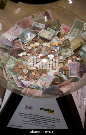 Box collection / collecting foreign currency / small change / money / cash / coins for charity at Heathrow airport, London. UK. Stock Photo