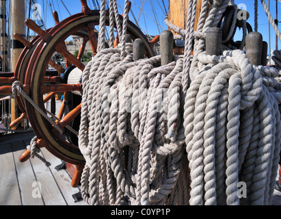 Ropes coiled around belaying pins at the Grand Turk / Etoile du Roy, frigate replica of HMS Blandford, Saint-Malo, Brittany Stock Photo