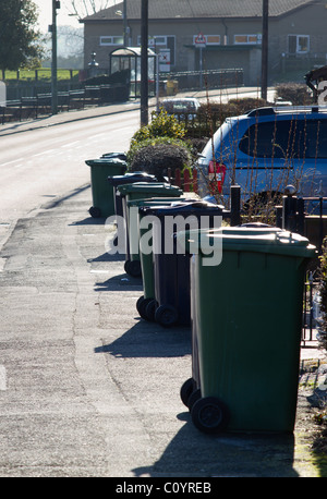 Emptied household green bins and garbage bins are left on the street ...