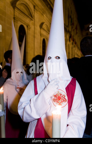 Church member  – thinking / in deep thought & eye peeping / eyes left . Semana Santa Easter Holy week procession. Seville Spain. Stock Photo