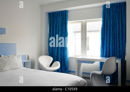 Arne jacobsen Swan chair and white panton chair in bedroom at the Big Sleep 1970s boutique hotel Stock Photo