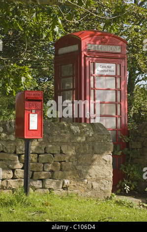 Street furniture - red post box & iconic historic K6 telephone box by drystone wall in scenic rural village - Leathley, North Yorkshire, England, UK. Stock Photo