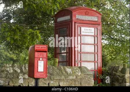 Street furniture - red post box & iconic historic K6 telephone box by drystone wall in scenic rural village - Leathley, North Yorkshire, England, UK. Stock Photo