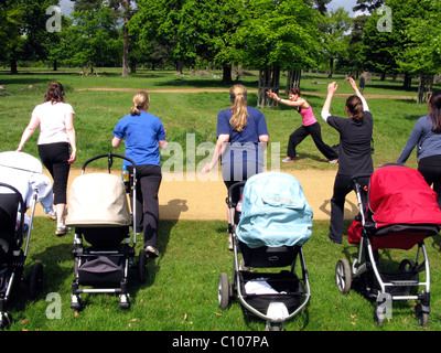Mothers in a park taking part in an outdoor exercise class Stock Photo