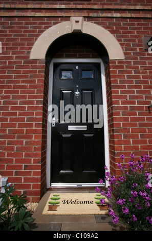 Front door to a house with a welcome door mat Stock Photo
