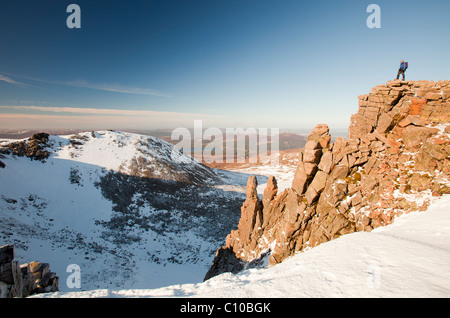A mountaineer on a rocky granite outcrop above Coire an Lochain in the Cairngorm Mountains, Scotland, UK. Stock Photo