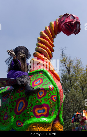 Girl dressed as a Catrina and riding a monumental alebrije during a parade in Mexico city Stock Photo