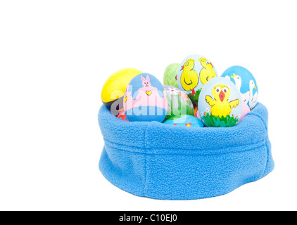Delightfully colorful hand painted Easter eggs nested in blue fleece on white background Stock Photo