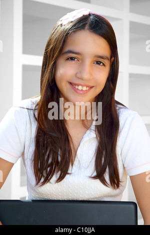 Latin teenager student smiling holding laptop indoor white house Stock Photo