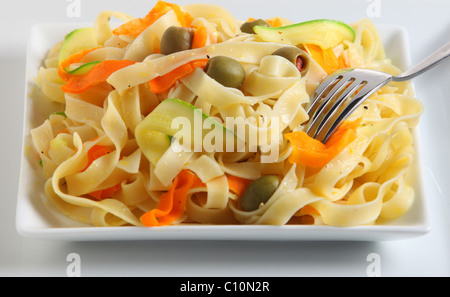 Tagliatelle with ribbons of carrot and courgette, stuffed olives and black pepper, tossed in a garlic flavoured olive oil, Stock Photo