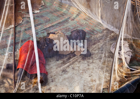 Tsemai girl sleeps under a mosquito net in Ethiopia Stock Photo