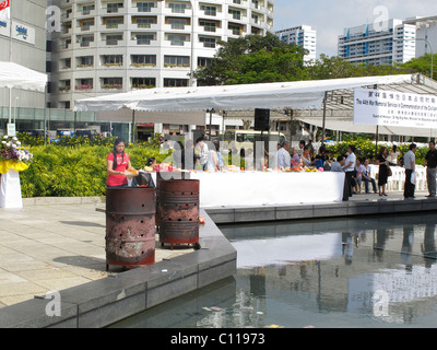 Food set out for the dead by Buddhists at  The Memorial to the Victims of the Japanese Occupation in Singapore and burning money Stock Photo