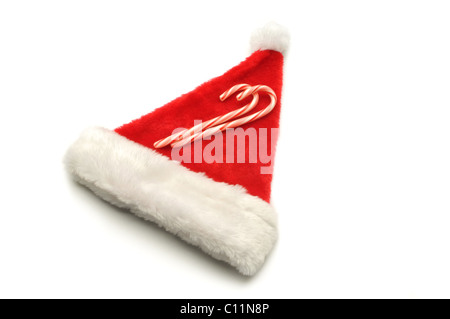 red Santa hat on white background with candy canes Stock Photo