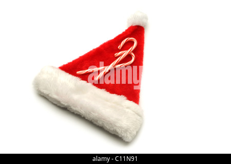 red Santa hat on white background with candy canes Stock Photo