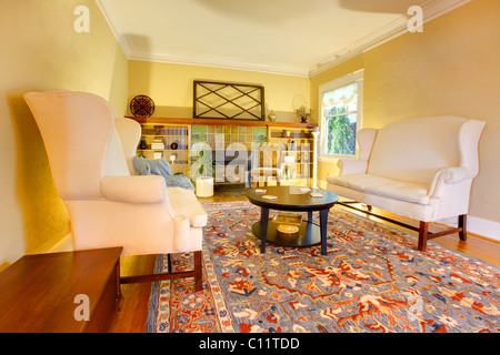 Luxury gold living room with two white sofas, rug and fireplace Stock Photo