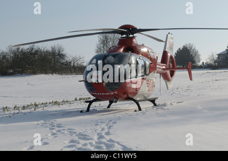 Rescue Helicopter Christoph 41, identifier D-HDRC, landing on a snow-covered meadow, Stuttgart, Baden-Wuerttemberg Stock Photo