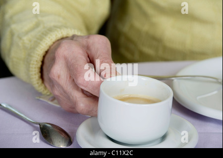 Old man's hand holding a cup of coffee, Germany, Europe Stock Photo