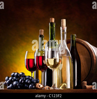 Still life with wine bottles, glasses and oak barrels. Stock Photo