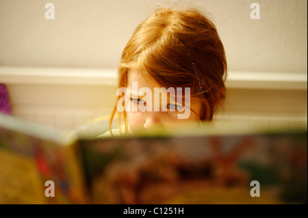 Child, girl reading in bed Stock Photo