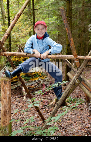 Boy, 7 years old, in a forest, climbing, autumn Stock Photo