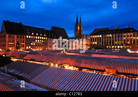 View of the Christkindlesmarkt Christmas market with evening lights, on the left the Sebalduskirche church, in the back the city Stock Photo