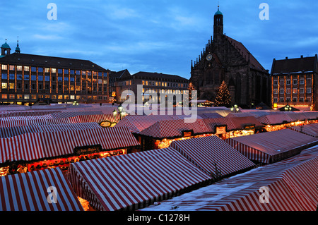 View of the Christkindlesmarkt Christmas market with evening lights, on the right the Frauenkirche Church of Our Lady Stock Photo