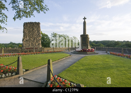 Red poppies on WW1 & WW2 war memorial (scenic landscaped grounds, historic ruin, flowers) - Knaresborough Castle garden, North Yorkshire England UK. Stock Photo