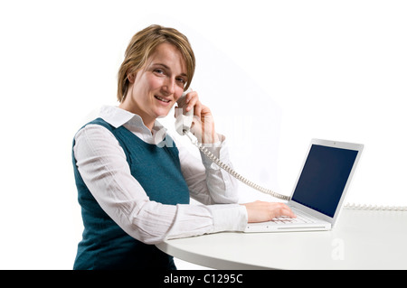 Young woman with telephone and computer Stock Photo