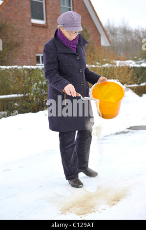 Women Spreading Sand On An Icy Sidewalk Stock Photo - Alamy